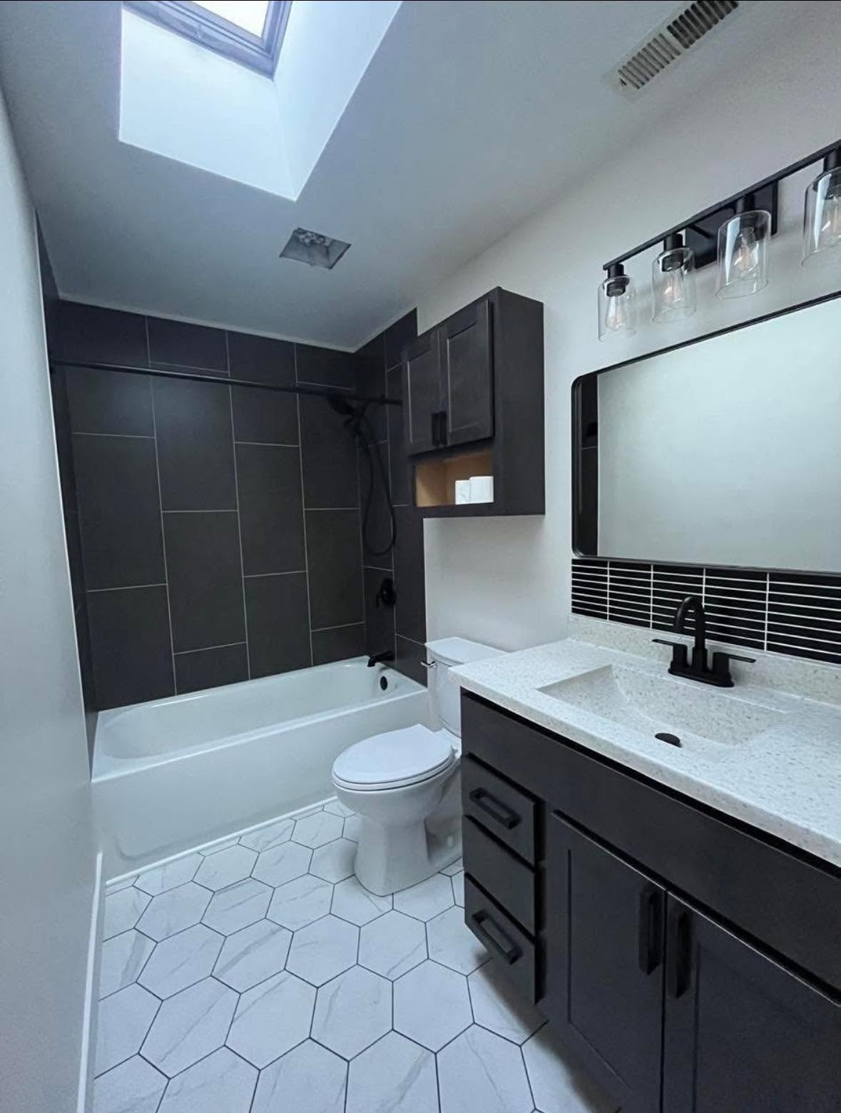 Dark tile bathroom with skylight NWI contractor